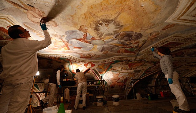 Restorers work on the ceiling of the San Lorenzo Chapel adjacent to the Holy Stairs in Rome March 11. Layers of grime on the chapel's Renaissance frescoes are being removed, bringing the original splendor of the artwork back to life. The project, which w ill include frescoes surrounding the Holy Stairs, is expected to last another five years. / Photo: (CNS photo/Paul Haring) (March 24, 2014)